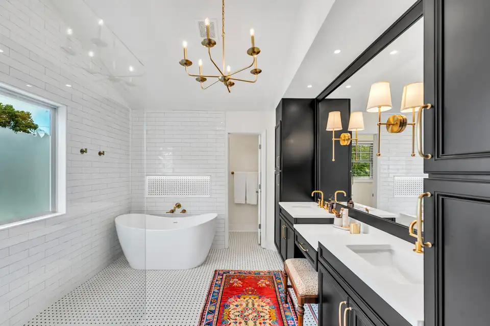 Bathroom remodeling Buford GA project: white subway tile walls, freestanding tub, black double vanity and brass chandelier